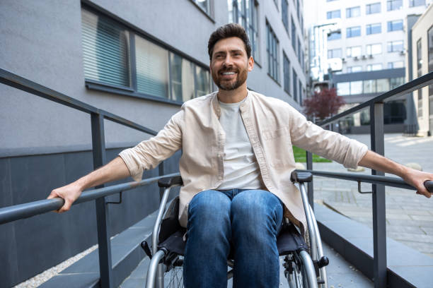 istock Disabled man on a wheelchair looking positive and smiling 2012887983