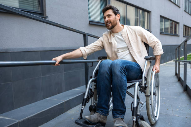 istock Disabled man on a wheelchair looking positive and smiling 2012887984