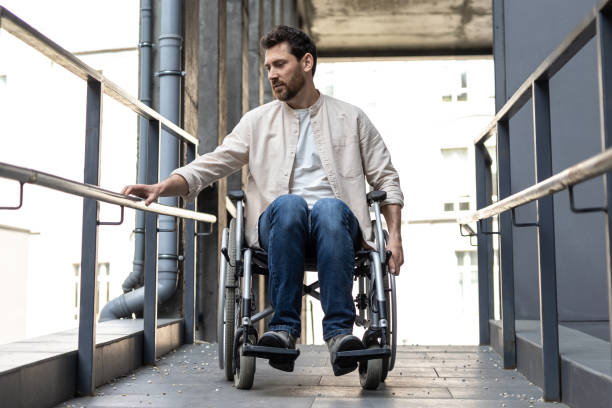 istock Dark-haired young caucasian man riding a wheelchair 2012887988
