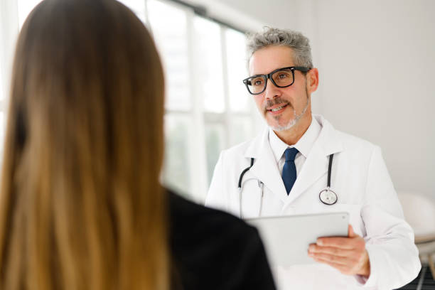 istock Experienced confident senior doctor with grey hair talks with a patient 2012888025