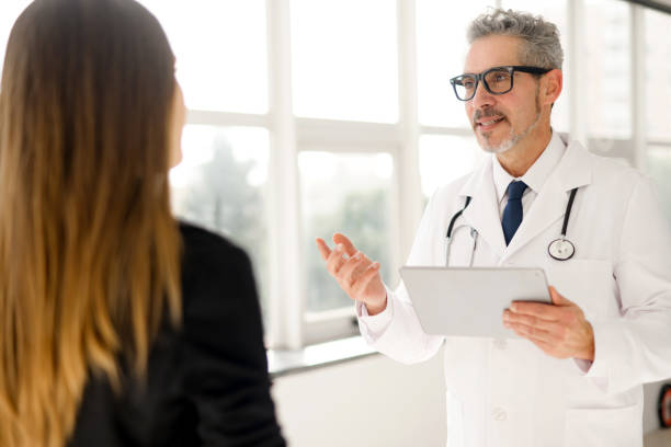 istock Experienced confident senior doctor with grey hair talks with a patient 2012888038