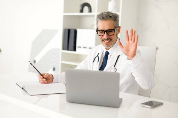 istock Experienced confident senior doctor with grey hair using laptop 2012888043