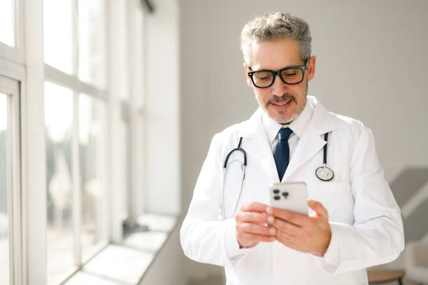 istock A doctor examines his smartphone in a clinical setting 2012888571