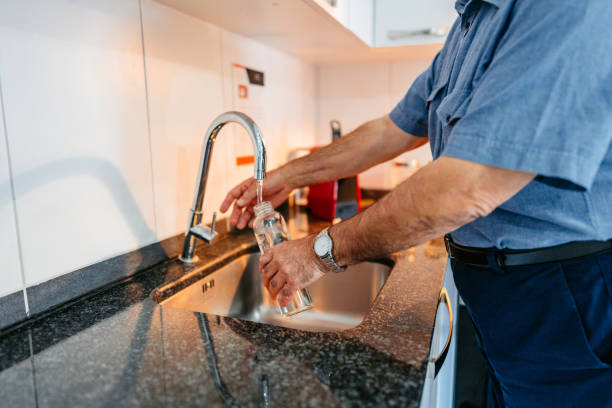 istock Senior Man Refiling His Glass Water Bottle With Water 2012889186