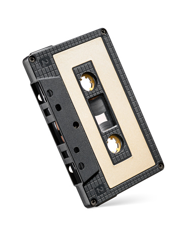 Black audio cassette tape isolated on white background. Yellow paper label.