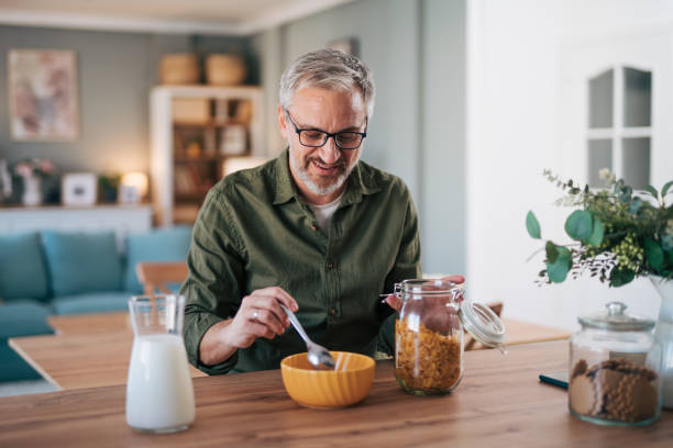 istock Man prepares a healthy breakfast, cornflakes with milk 2012900522