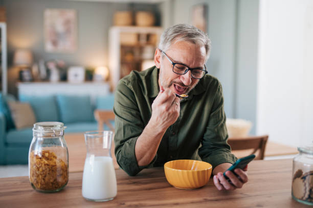 istock Happy senior man reading online newspaper while having breakfast 2012907687