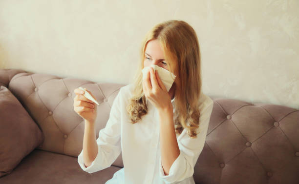istock Sick woman sneezing blow nose using tissue measuring checking body temperature with thermometer 2012923059