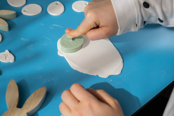 istock Workshop cutting figures Unrecognizable artist do it yourself air dry clay crafts for Easter holiday. Decoration gift idea Handmade children craft. Step by step instruction of painting, pressing figures 2012936192