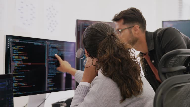 Software developers discussing compling source code and recovery bugs. Programmer teamwork are editing and programmers working on real time in the software development office.