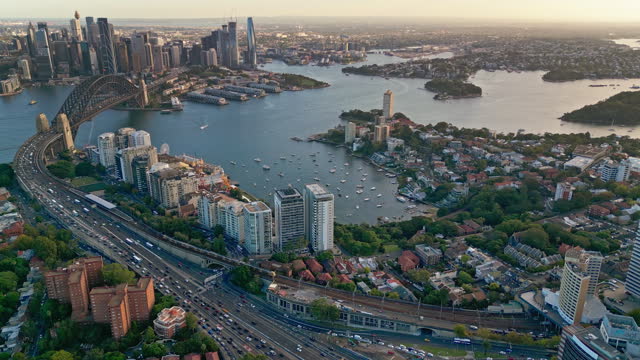 4K Aerial view Real time Footage of above Crowded Traffic and transportation on expressway though Sydney Harbour Bridge, Lavender bay and Circular Quay, Australia