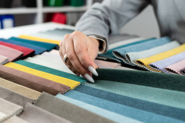 istock close up female designer hand choosing fabric among colorful samples at office 2012964096