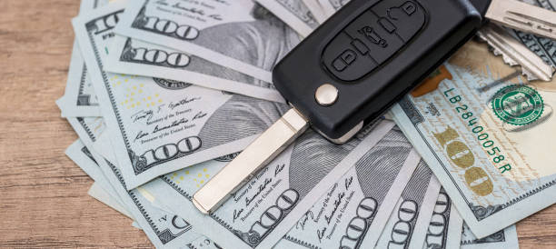 istock black car key on dollar paper money on desk 2012978366