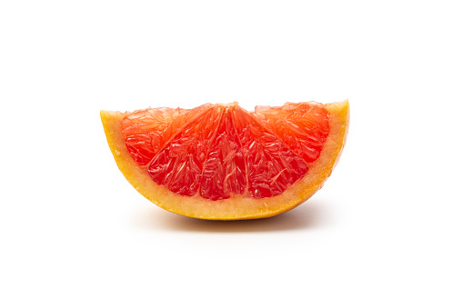 Side view of a Wedge of pink grapefruit citrus fruit isolated on white, studio shot.