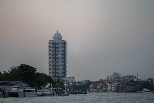 Bangkok, Thailand - January 29 2024: Twilight Skyline with Waterfront Buildings and Distant High-Rise