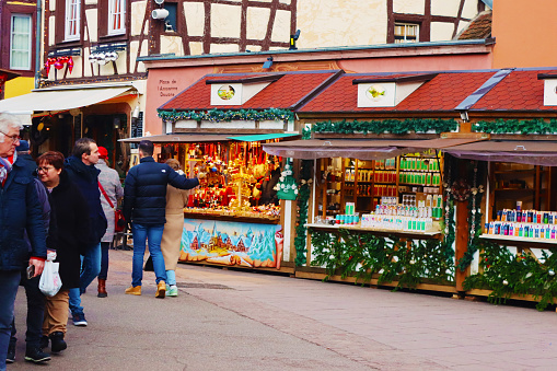 Colmar, France - December 21, 2023: Christmas market on Old customs square. Unidentified people are walking on street of old town. A lot of tourists like to visit Colmar during Christmas celebration