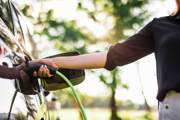 istock Hand plugging in a charger in the electric car charging socket 2013070960