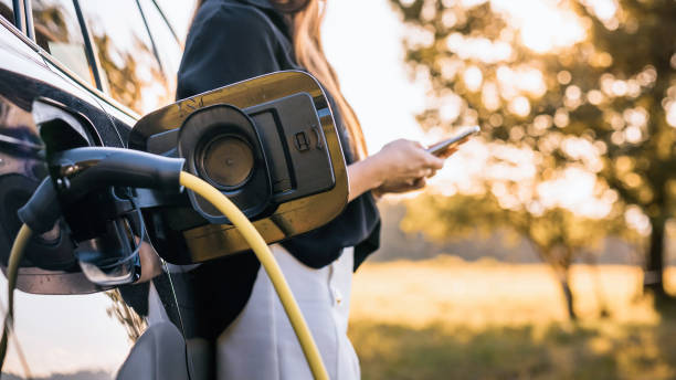 istock Woman charging parked electric car 2013078593