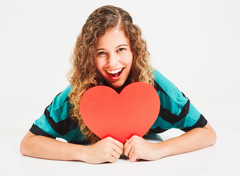 Curly-haired young beauty looks happy and excited about her romantic prospects.