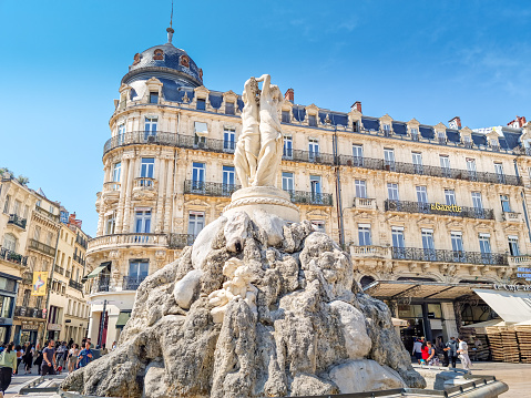 Montpellier, France - 22 May 2023: People walking in the Place de la Comedie square by the Three Graces fountain. The Place is the focal point of the city.