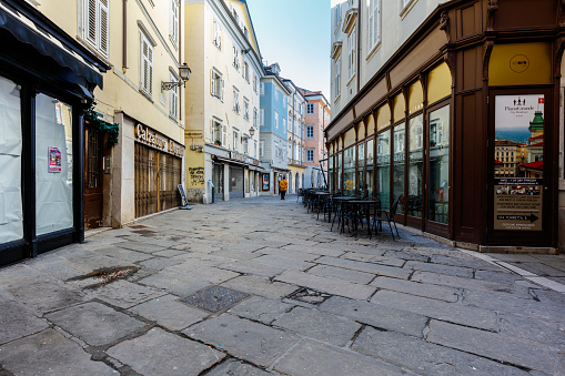 Trieste, Italy - February 13, 2024: Old town street on a cloudy day.