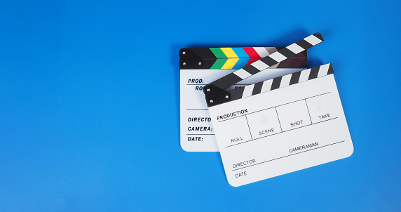 Two Clapper board or movie slate on blue background.