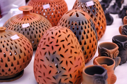 A vertical closeup shot of hands sculpting a clay vase
