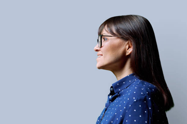 istock Profile view of middle aged smiling woman, gray background, copy space 2013090792