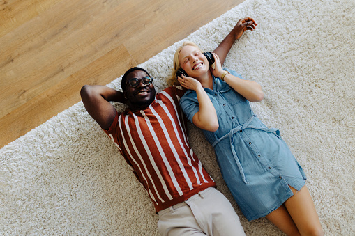 Happy young couple lying on the floor at new home