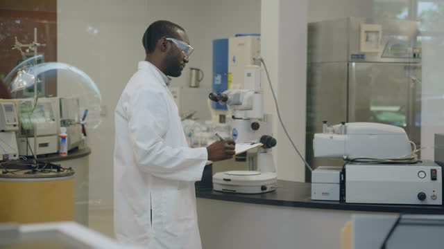 Male scientist takes notes while working in lab