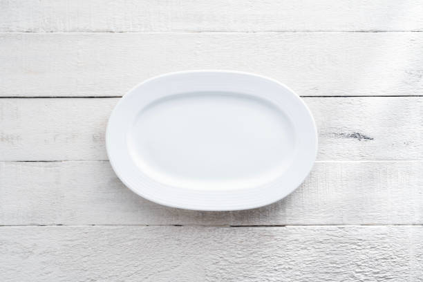 Blank white small plate on wood background