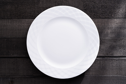 Blank white large plate on wood background