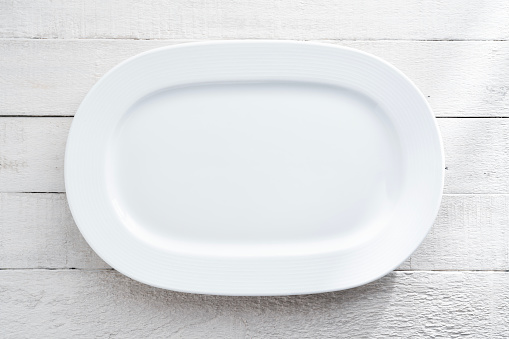 Blank white large plate on wood background