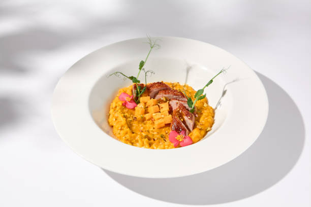 istock Elegant duck breast with pumpkin risotto in a shadowy white ambiance, perfect for sophisticated culinary presentations 2013146847