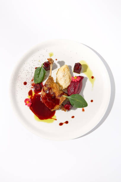 istock Duck leg confit with berry sauce on a white background, top view - a gourmet delight for fine dining establishments 2013157521