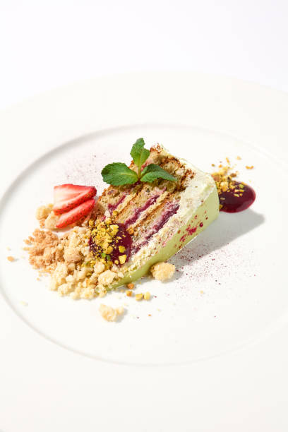 istock Pistachio cake with a raspberry layer and crumbled cookie and pistachio topping on an isolated white background 2013157536
