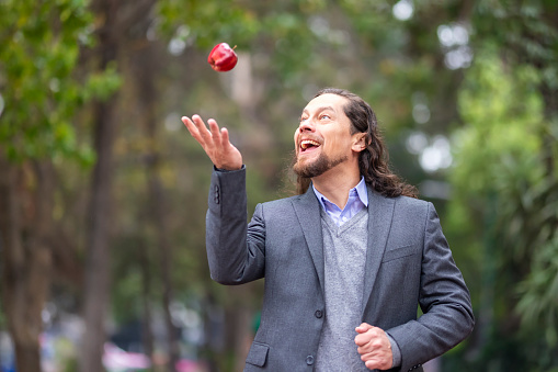 Man playing with an apple