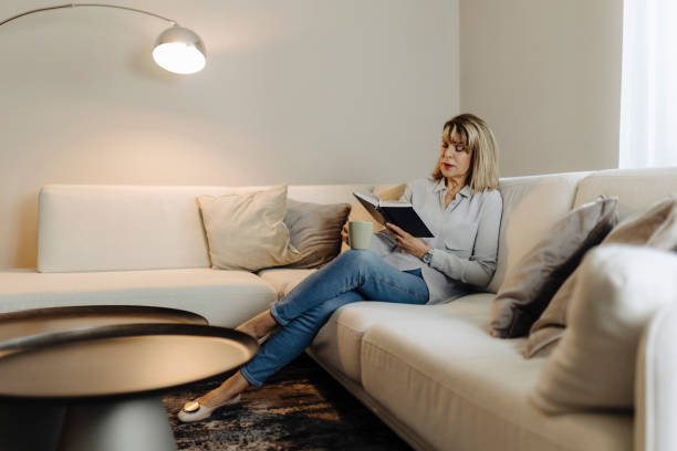 istock Senior woman reading book at home 2013171887