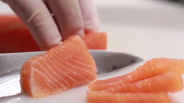 Chef Sushiman hands slicing salmon for sashimi