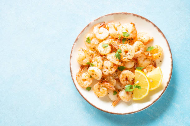 istock Fried shrimps with herbs and olive oil at blue table. 2013249074