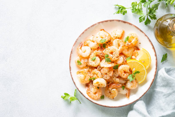 istock Shrimps with spices in craft plate at white stone table. 2013249089
