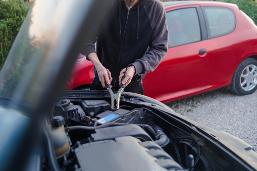 Portrait of a male mechanic showing a clipboard with road trip tips, shot on the road