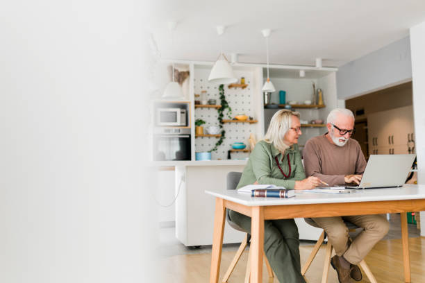 istock Senior couple using laptop while planning their home budget, 2013275781