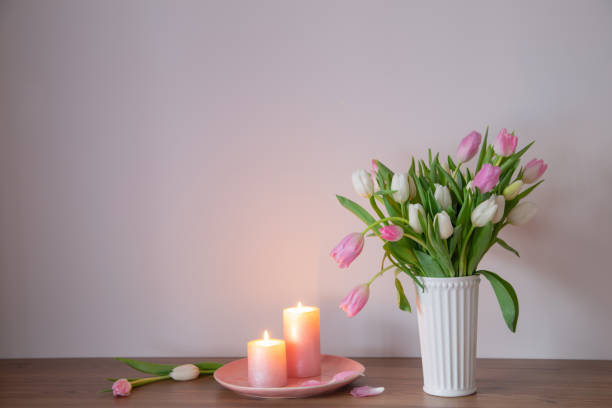 istock spring tulips in vase with burning candles on wooden shelf 2013277928
