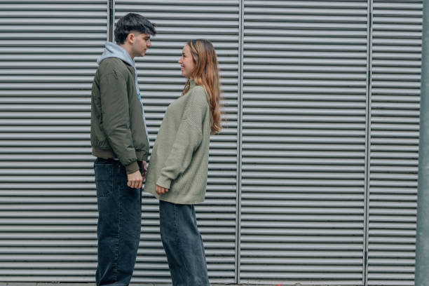 istock young couple on the street in profile talking 2013297638
