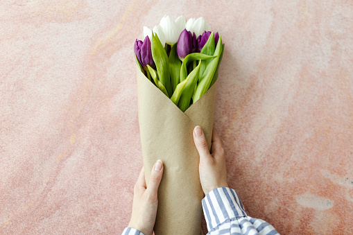 Photo of human hands creating tulip bouquet
