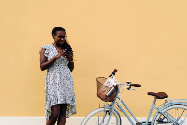istock Woman using her smart phone while standing near her bicycle 2013324955