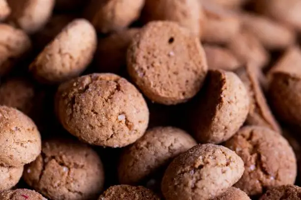A tasty closeup portrait of a pile of delicious traditional dutch snacks called pepernoten or pepernuts. The gingerbread treat is a tradition during the holidays and sinterklaas or saint nicholas.