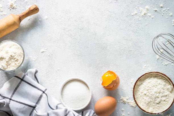 istock Baking background ingredients. Flour, sugar, eggs and rolling pin at light stone table. 2013326013