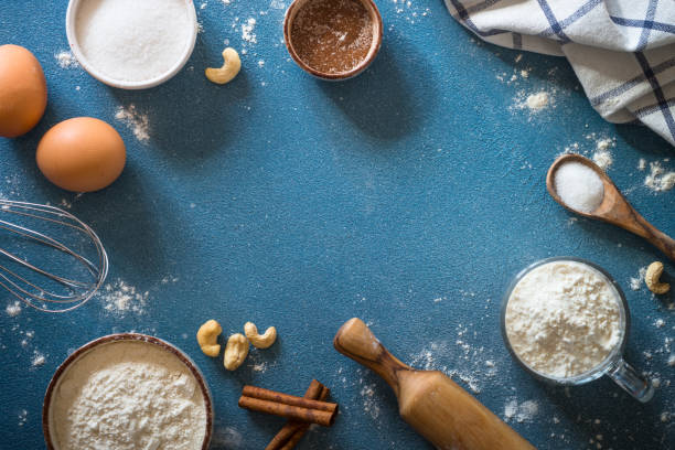 istock Baking background ingredients. Flour, sugar, eggs and rolling pin at blue stone table. 2013326582